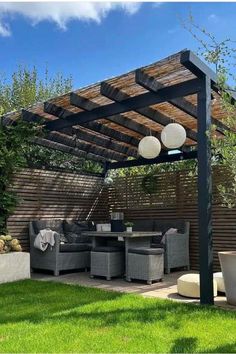 an outdoor living area with couches, tables and chairs under a pergolated roof