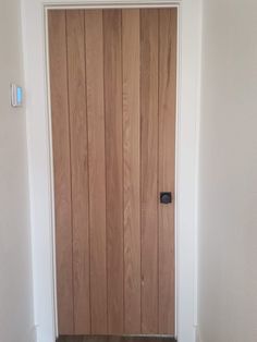 a wooden door in a white room