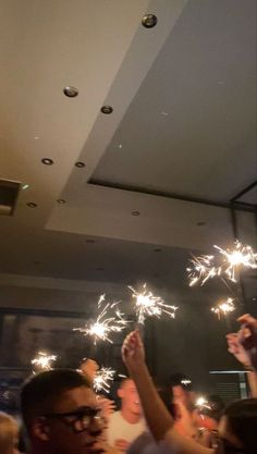 a group of people holding sparklers up in the air