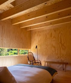 a bedroom with wood paneling and a rocking chair on the bed in front of it