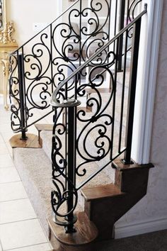 an iron stair railing with wooden steps in a house