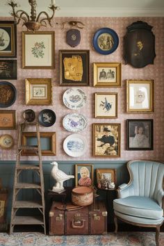 a room filled with lots of framed pictures on the wall next to a blue chair