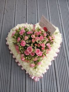 a heart shaped arrangement with pink and white flowers