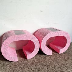 two pink sculptures sitting next to each other on the floor