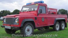 an old red truck parked in the grass