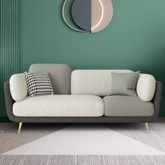 a living room with green walls and a white couch in front of a round mirror