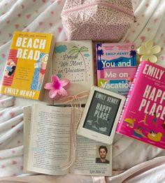 there are many books on the bed and one is in a pink bag next to it