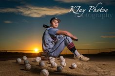 a man sitting on top of a baseball field holding a bat next to some balls