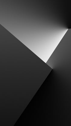 an abstract black and white photo with light coming from the top, revealing a triangular shape