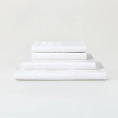 three white sheets are stacked on top of each other in front of a plain background