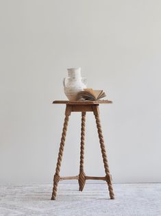 a white vase sitting on top of a wooden table