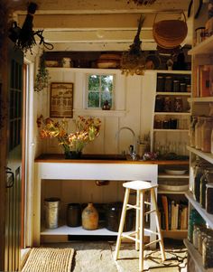 a kitchen with lots of shelves filled with pots and pans