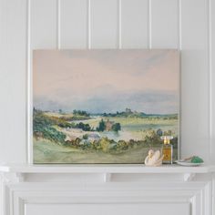 a painting on a mantle in a room with white walls and wood trimmings