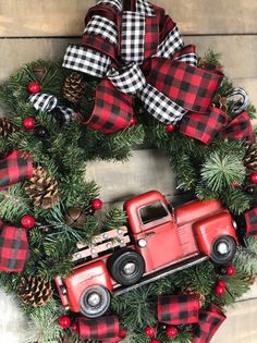 a wreath with a red truck and pine cones