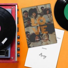 an old record player and album on top of a table next to it's contents