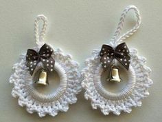 two bells are attached to a white crochet ornament with a bow