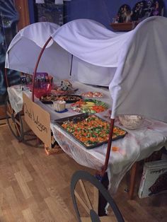 a table with food on it and an umbrella over the top that is covered in plastic