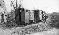 an old train car sitting on top of a pile of dirt next to a brick building