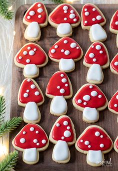 cookies decorated with red and white mushrooms on a wooden board