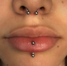 a woman's nose has three piercings on it