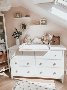 a baby's room with a dresser, crib and stuffed animals on it