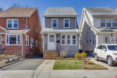 three houses in the same neighborhood with one car parked on the street and another house behind it