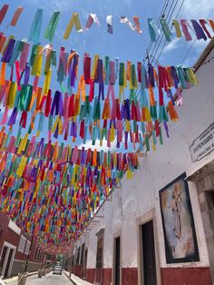 multicolored streamers hanging from the ceiling in front of a building on a sunny day