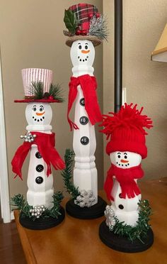 three snowmen with hats and scarves on their heads