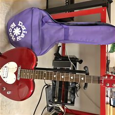 a purple guitar case sitting on top of a red guitar