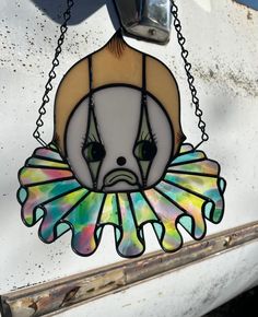 a stained glass window hanging on the side of a white truck with a bird in it's mouth