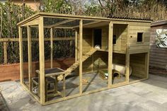 a chicken coop in the middle of a backyard with stairs leading up to it's roof