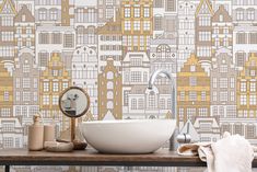 a bathroom sink sitting under a mirror next to a wallpaper covered in yellow buildings