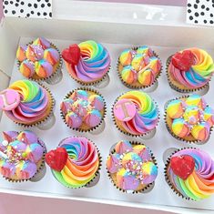 cupcakes with rainbow frosting and sprinkles in a box