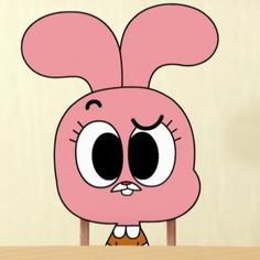 an animated pink bunny sitting on top of a wooden table next to a white wall