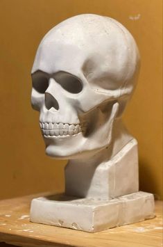 a white skull statue sitting on top of a wooden table