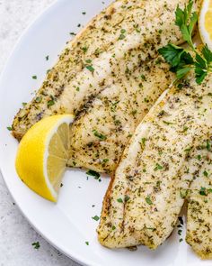 fish with herbs and lemon on a white plate