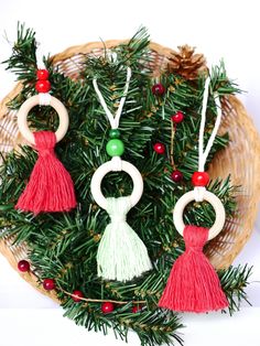 christmas ornaments made out of wooden rings and tassels on top of a basket