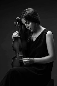 a woman in black dress holding a violin