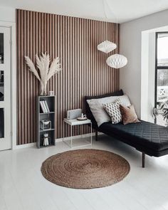 a living room with striped wallpaper and black sofa