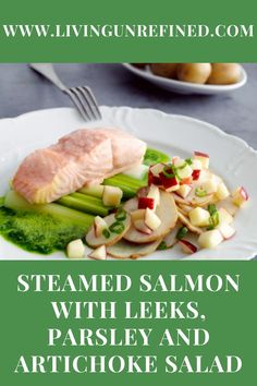 steamed salmon with leeks, parsley and artichoke salad on a white plate