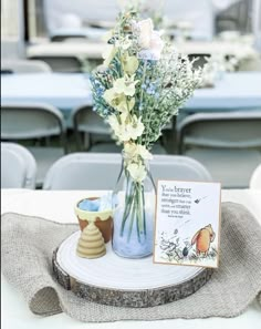 there is a vase with flowers in it and a card on the table next to it