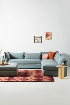 a living room with a blue sectional couch and coffee table on top of a rug