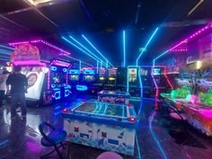 a room filled with arcade machines and neon lights