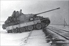 an old tank is driving through the snow