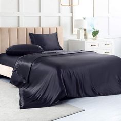 a bed with black sheets and pillows in a room