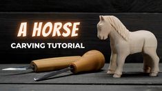 a wooden horse next to a carving knife and some wood shaving tools on a table