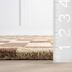 a ruler is next to a brown and white rug