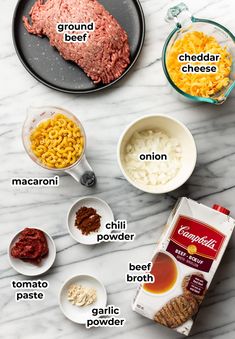 ingredients to make ground beef macaroni and cheese on a marble counter top with text overlay