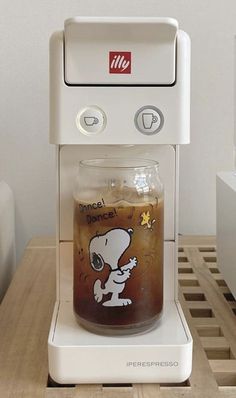 a coffee maker with a glass filled with liquid