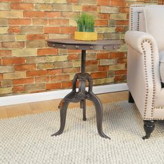 a chair and table in front of a brick wall with a potted plant on it